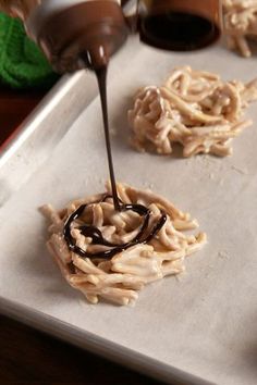 chocolate sauce being poured on top of noodles