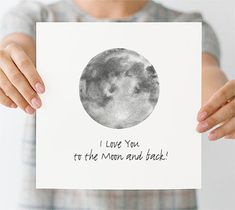 a person holding up a card that says i love you to the moon and back