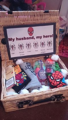 a wicker basket filled with lots of items on top of a wooden table next to a sign that says, my husband, my hero