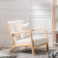 a white chair sitting on top of a rug next to a book shelf filled with books