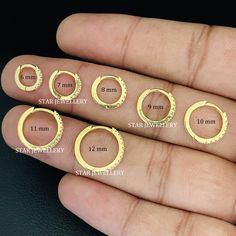 four different sizes of rings on someone's finger, with the measurements displayed below them