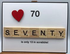 a scrabbled wooden block with the words seventy and a red heart