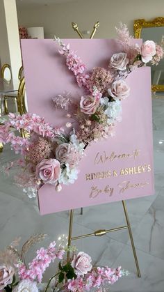 a welcome sign with pink flowers and greenery