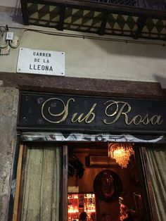 the entrance to a restaurant called sub roca in an old building with gold lettering and chandeliers hanging from the ceiling