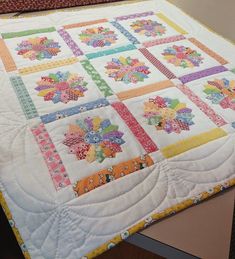 a quilted table topper with flowers on it