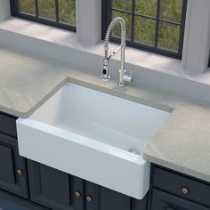 a white sink sitting under a window next to a faucet in a kitchen