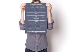 a woman holding up a poster with sound waves on it's face and hands