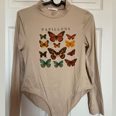 a shirt with butterflies on it hanging from a hanger in front of a door