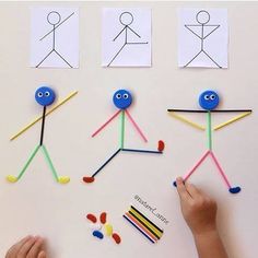 someone is making stick people out of construction paper and colored crayon pencils