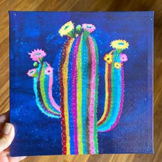 a painting of a cactus with flowers painted on it