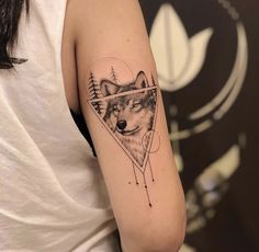 a woman with a wolf tattoo on her arm