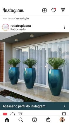 three large blue vases sitting on top of a window sill in front of a house