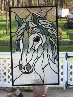 a stained glass window with a horse in the center and green leaves on its head