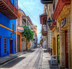 an empty street with blue and yellow buildings