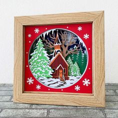 a wooden frame with a christmas scene in the center and snowflakes around it