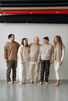 a group of people standing next to each other in front of a large piece of art