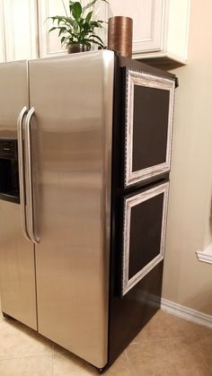 a silver refrigerator freezer sitting inside of a kitchen next to a potted plant