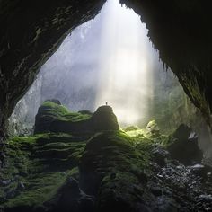 the light shines through an opening in a mossy cave