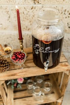 there is a glass jar with some liquid in it on a wooden shelf next to other items