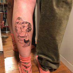 a woman's leg with a cartoon character tattoo on it and her legs crossed