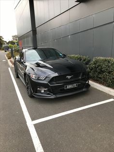 a black mustang parked in a parking lot