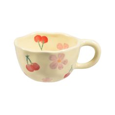 a small cup with flowers painted on it