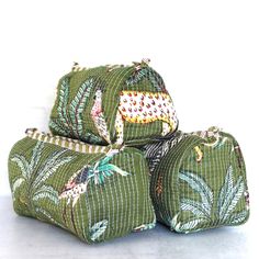 four green bags are stacked on top of each other, one has an animal and the other has leaves