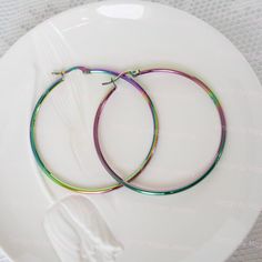 Add a pop of color with these versatile and hypoallergenic hoop beauties. Get some fun with these lightweight and sturdy hoops that are just perfect for a day or night  wear.  Here are some key features of Melissa hoop earrings: * Material: Stainless steel  * Hinged Post earrings to ensure secure fit. * Finish: colorful Rainbow  * Style: Classic  * Hoop Size: Approximately 50 mm  * Weight: Lightweight  * Features: Hypoallergenic, fade resistant, comfortable to wear, Eco freindly. Packaging: Each Eco Freindly, Rainbow Style, Rainbow Fashion, Night Wear, Colorful Rainbow, Earrings Color, Jewelry Earrings Hoops, Style Classic, Color Shades