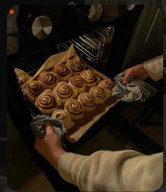 a person is baking cinnamon rolls in the oven