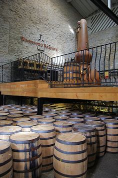 several wooden barrels stacked on top of each other in front of a brick wall and staircase