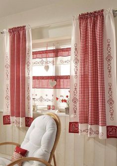 a chair sitting in front of a window with red and white checkered drapes