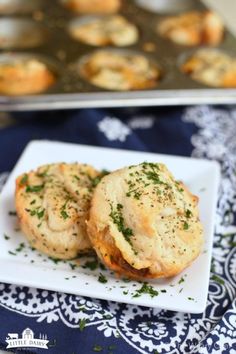 two biscuits on a plate next to a muffin tin