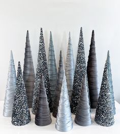 there are many small silver trees on the table