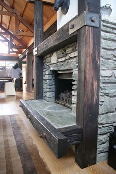 an old fireplace is in the middle of a room with wood floors and stone walls