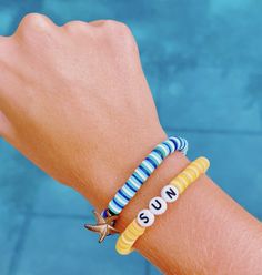 a person's arm wearing two bracelets with the word suns written on them