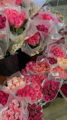 a bunch of flowers that are sitting on the ground in front of each other and wrapped in cellophane