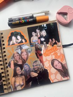 an open notebook with photos and pencils on it