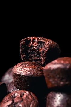 chocolate muffins stacked on top of each other in front of a black background