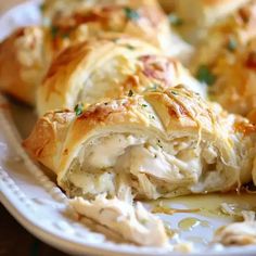 a close up of a plate of food with meat and cheese wrapped in bread on it