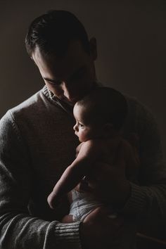 a man holding a baby in his arms