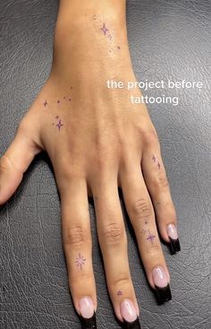 a woman's hand with pink nail polish and stars on her left wrist, next to the words the project before tattooing