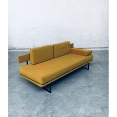 a yellow couch sitting on top of a cement floor