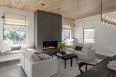 a living room filled with furniture and a fire place in the middle of a room