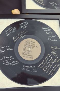 two black and white records with autographed names are on display in a glass case