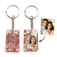 two square key chains with an image of a man and woman in the middle one has a photo attached to it