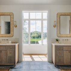 a bathroom with double sinks and mirrors in front of a large open door that leads to the outside