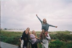 a group of young women standing next to each other on top of a wooden walkway