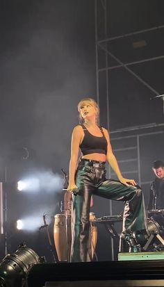 a woman standing on top of a stage in front of microphones and other instruments