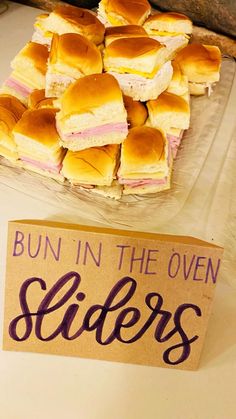 buns in the oven sliders are sitting on a table next to a sign