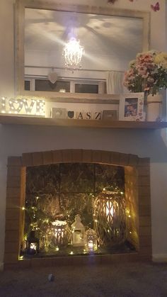 the fireplace is decorated with candles and flowers